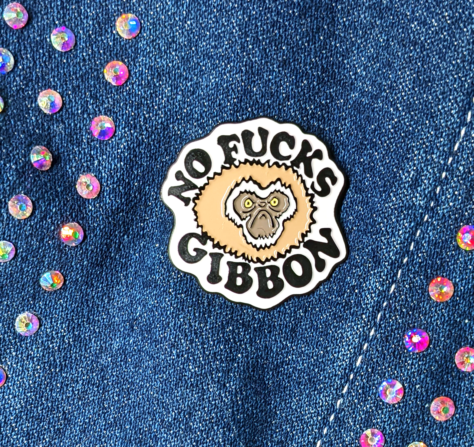 no fucks gibbon pin displayed on a jean jacket