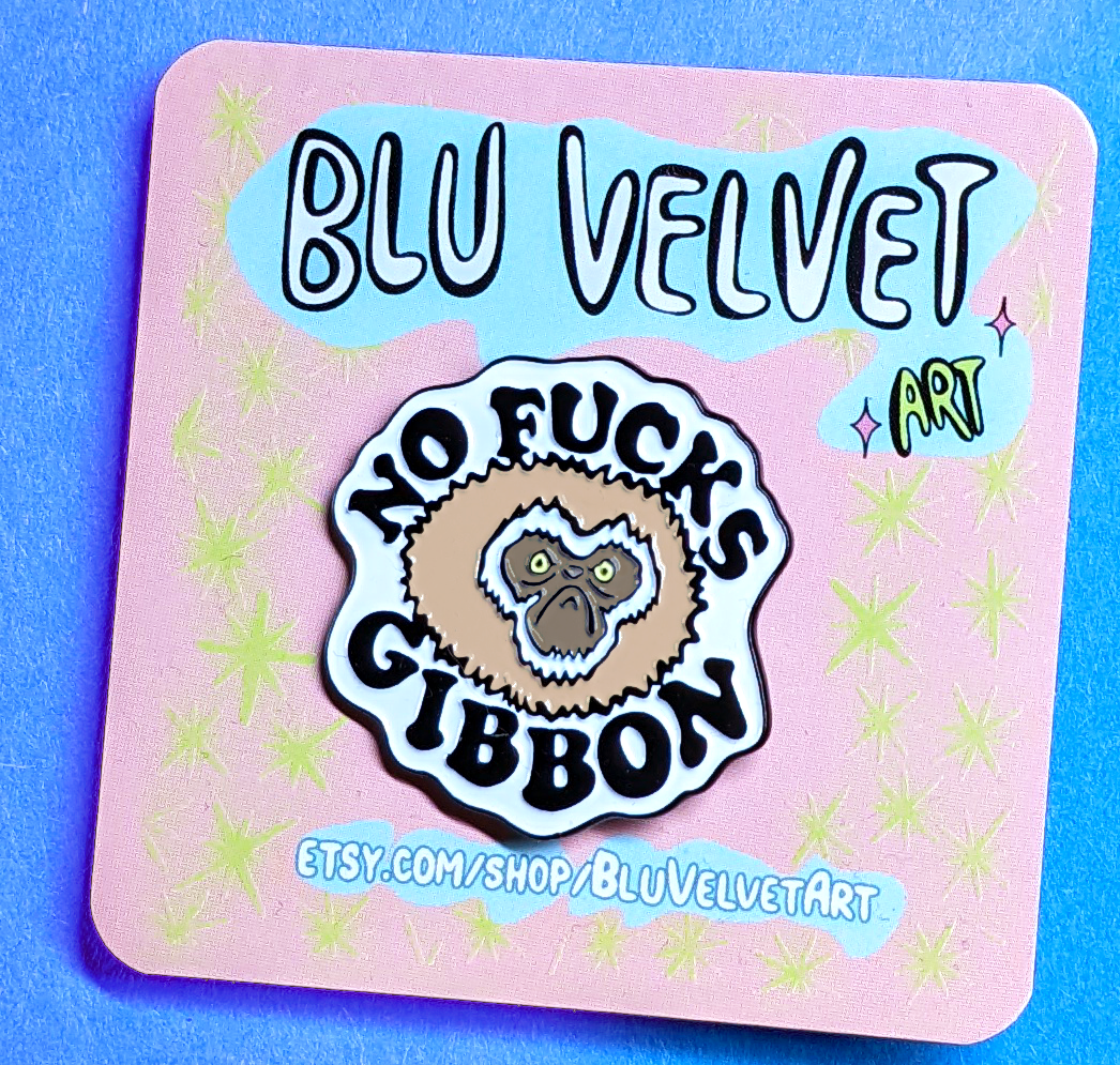 no fucks given pin is displayed on a backing card