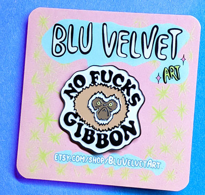 no fucks given pin is displayed on a backing card