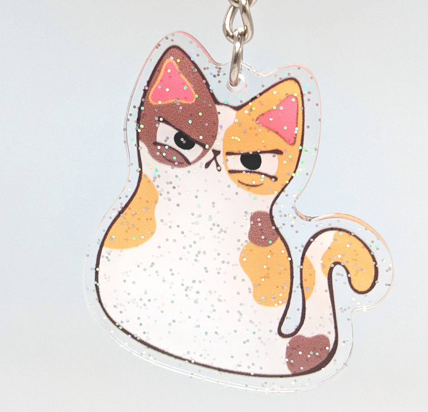 Cute judgy calico cat keychain with glitter sparkles. A kawaii fashion gift for cat lovers