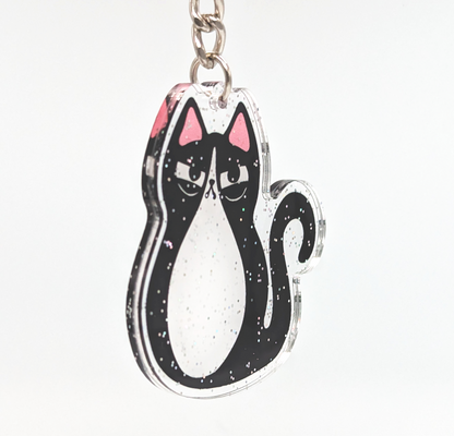 Sideview of tuxedo cat acrylic glitter keychain