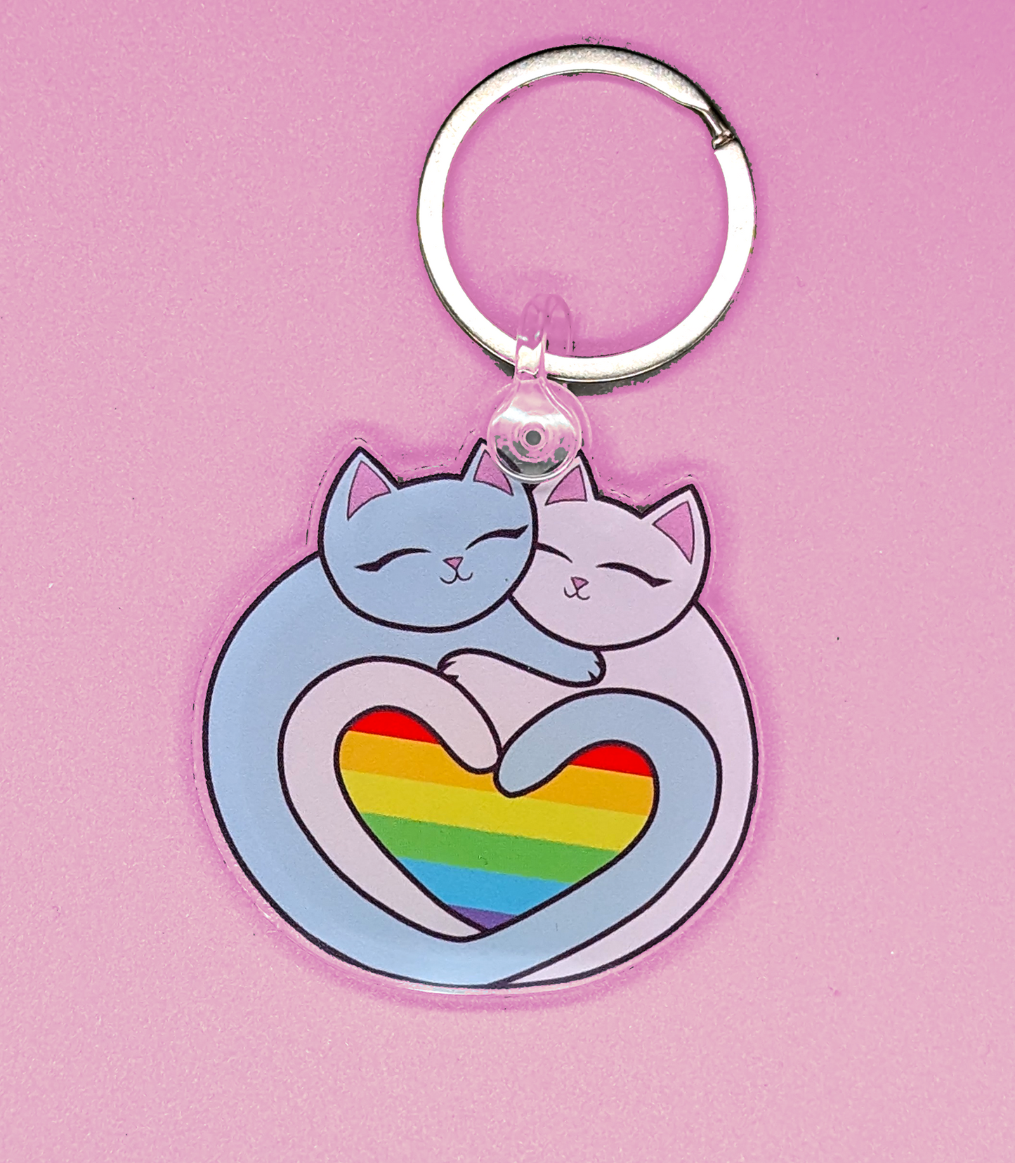 Rainbow Heart Pride Flag Cats Keychain has two cats forming a heart with their tales. Within the heart is a rainbow pride flag