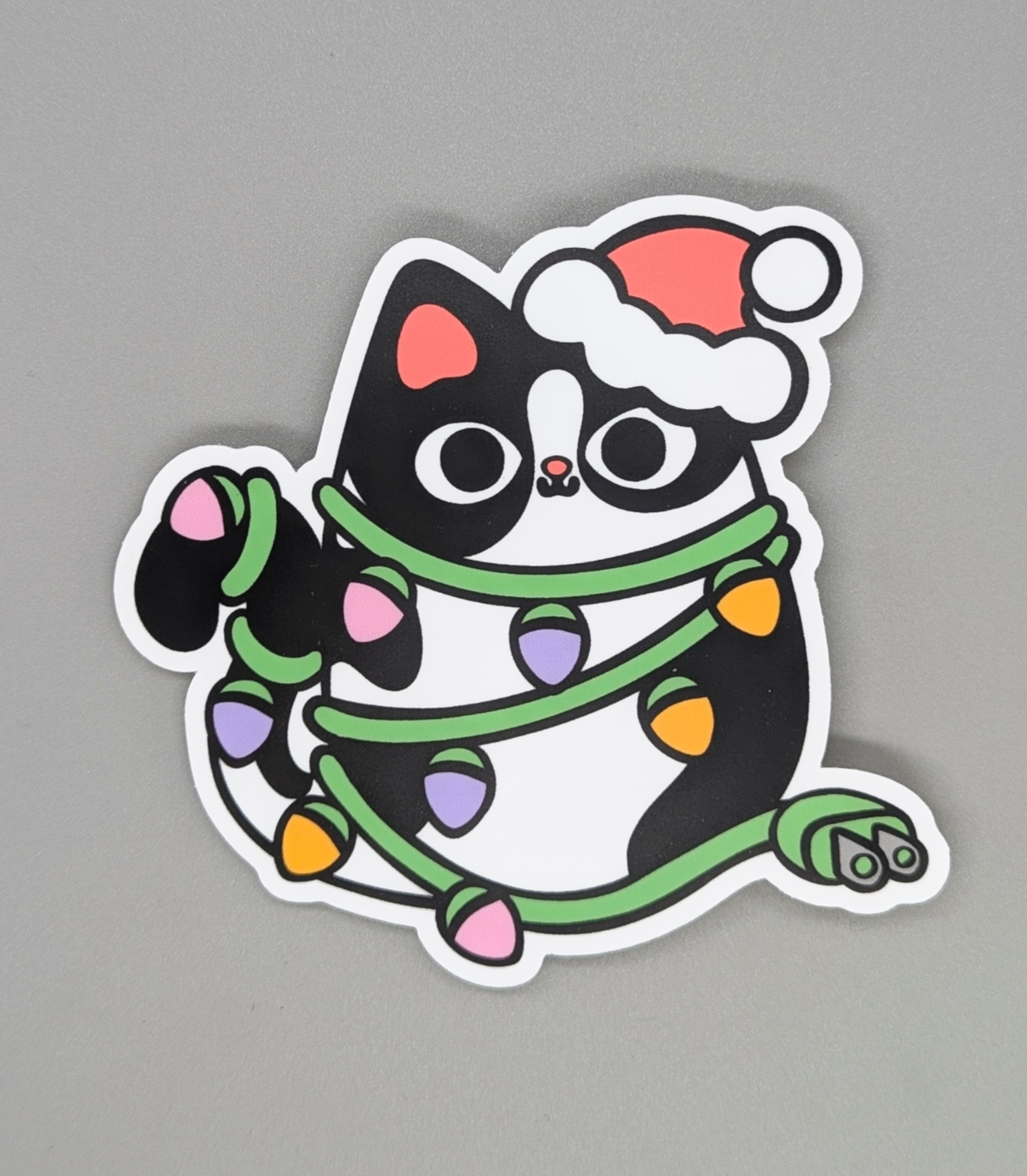 The cat got into the Christmas lights again! A jumbo sticker that's 4 inches!