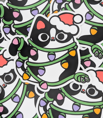 Sticker of a cat wrapped in Christmas lights with a Santa hat on a white background.
