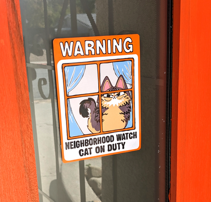 Angry Fluffy Tabby Cat Neighborhood Watch Cat Window Cling that reads Warning Neighborhood watch cat on duty is displayed on Red Door