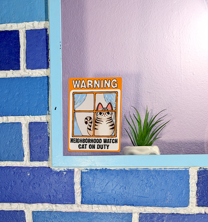 silly cat pun window cling of an angry tabby cat that reads neighborhood watch cat on duty