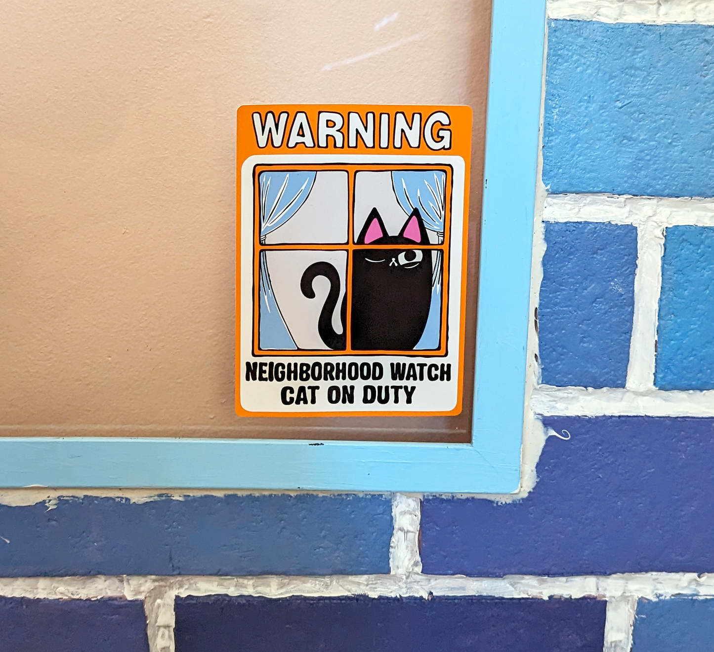 Cartoon black cat with one eye on a window cling. Cat art reads Warning: Neighborhood Watch Cat on Duty