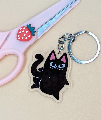 Caked Up Kitty Judgy Cat Acrylic Keychain shows black cat with big booty