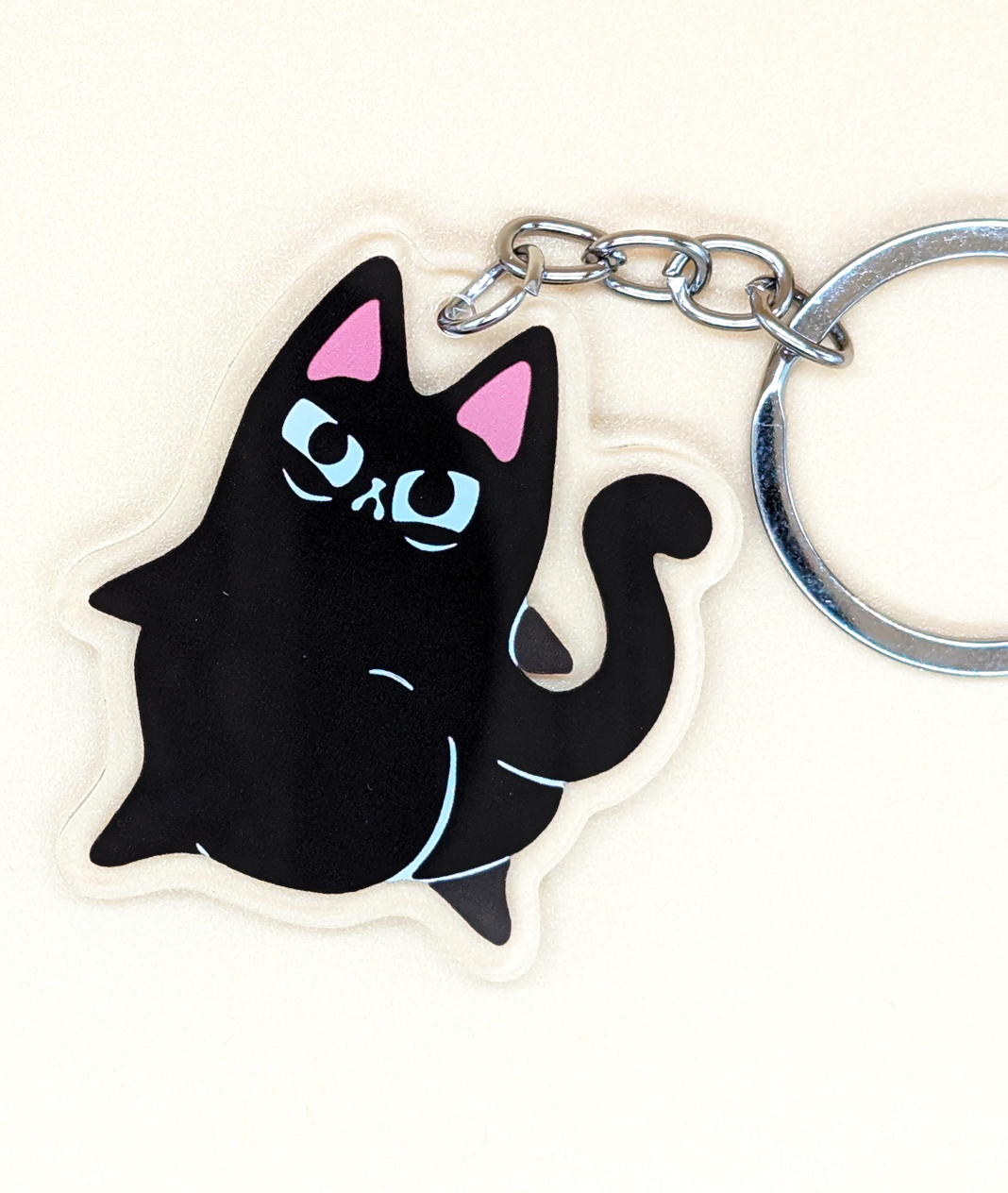 Caked Up Kitty Judgy Cat Acrylic Keychain show black cat with big butt