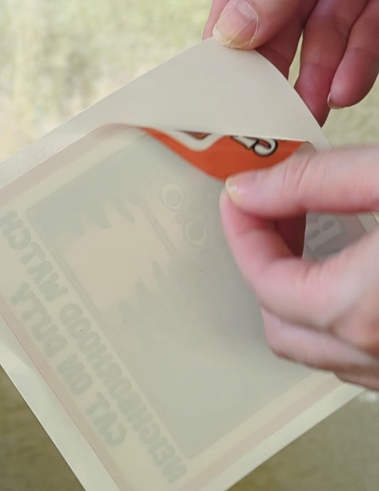 Cute Cartoon Tabby Cat art on a window cling being peeled and stuck onto window